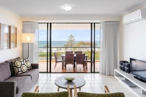 a living room with a couch and a table at Oaks Sunshine Coast Seaforth Resort in Alexandra Headland