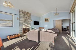 タウランガにあるHill Top House - Tauranga Holiday Homeのテーブルと暖炉のあるリビングルーム