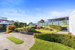 タウランガにあるBay View Gardens - Tauranga Holiday Homeの建物の隣にある生け垣のある家