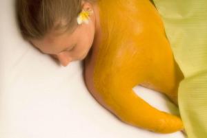 a young child is sleeping next to a yellow object at Pool Villa Merumatta Senggigi in Senggigi