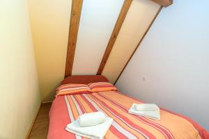 a small bedroom with a bed with towels on it at Pool & Wellness Twin Chalets Zavrh in Šimatovo
