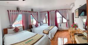 une chambre d'hôtel avec deux lits et des fenêtres dans l'établissement olivia Hotel, à Sa Pa