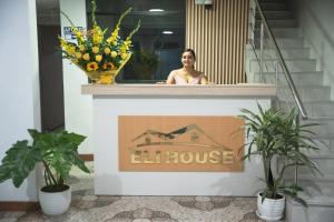 Eine Frau, die auf dem Sims eines Lifthausschildes steht in der Unterkunft Hotel Eli House in Nazca