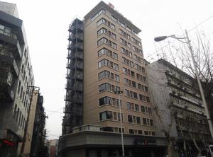 un edificio alto en medio de una ciudad en Jinjiang Inn Wuhan Zhonghua Road Hubu Alley, en Wuhan