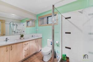 a bathroom with a toilet and a sink and a shower at Cozy Heaven Treeview House for Dream Trip in Springfield Lakes +24 photos
