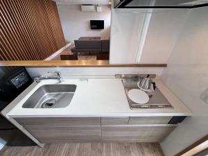 una pequeña cocina con fregadero y encimera en 島の宿 Amanzaーアマンツァー, en Ishigaki Island