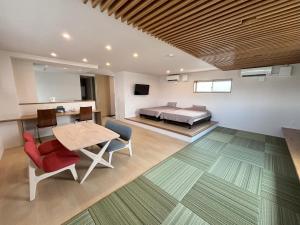 Un dormitorio con una cama y una mesa y sillas. en 島の宿 Amanzaーアマンツァー, en Ishigaki Island