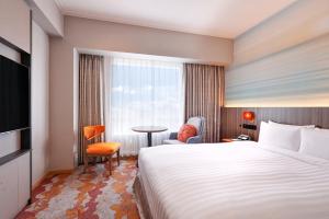 a hotel room with a bed and a window at Miyako Hotel Yokkaichi in Yokkaichi