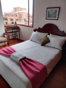 a bedroom with a bed with a purple blanket on it at Habitaciones en un alojamiento -Anfitrion - Elias Di Caprio in Bogotá
