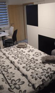 een slaapkamer met een bed met een deken met bloemen erop bij Liliana in Kaluža