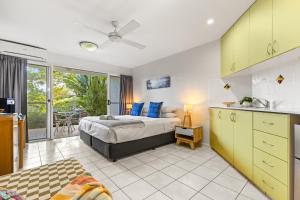 a bedroom with a king sized bed and a kitchen at Byron Getaway @ Eco Beach in Byron Bay