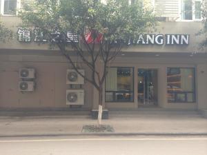 a building with a tree in front of it at Jinjiang Inn Yibin Zhongshan Street in Yibin