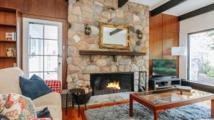 sala de estar con chimenea de piedra en White Hill Cottage, en Red Hill