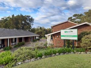 a building with a sign in front of it at Fifth Green Apartments in Mollymook