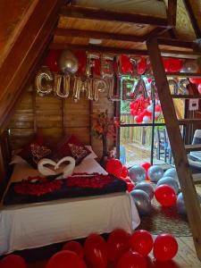 a room with balloons and a bed with a sign that says congratulations at Cabaña trébol del campo in Ebéjico