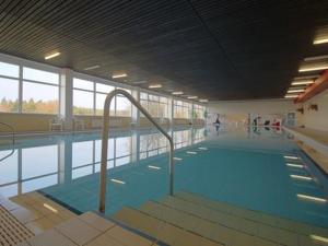 a large swimming pool with blue water in a building at Hexenstube Jorjina - WLAN - Garten- tolles Bad - Garage mit Wallbox- Brockenblick-Wandern -Mountainbike - Motorradurlaub in Braunlage