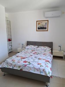 a bedroom with a bed with a floral comforter at Apartment Lidie in Ubli