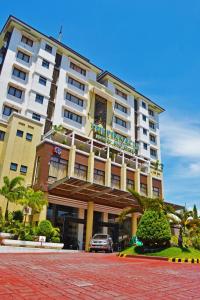 un hotel con un coche aparcado delante de él en The Pinnacle Hotel and Suites, en Davao City