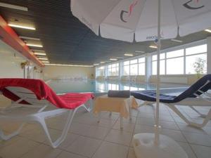 een zwembad met stoelen en een parasol in een kamer bij Hexenstube Jorjina - WLAN - Garten- tolles Bad -Wandern -Mountainbike - Motorradurlaub in Braunlage