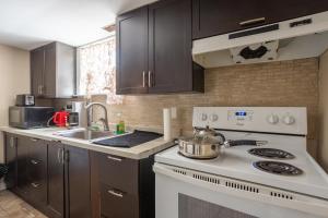 a kitchen with a white stove top oven next to a sink at Private room with TVnetflix and free parking in Pickering