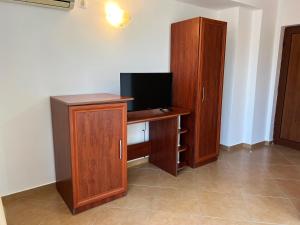 a computer desk with a monitor and a cabinet at Къща за гости Теодора in Tsarevo