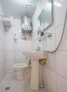 un bagno bianco con lavandino e WC di Kao Mama B&B a Jiufen