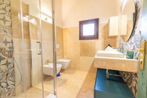a bathroom with a shower and a sink and a toilet at Villetta con Giardino - Lu Fraili in Nuragheddu +8 photos