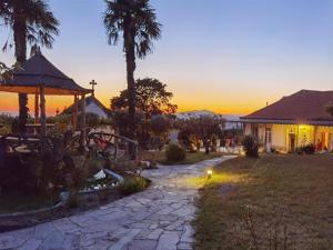 a sunset view of a house with a stone pathway at Resort Quinta do Sameiro in Vieira do Minho