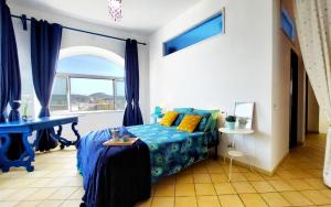 a bedroom with a blue bed and a window at Forio Family Home in Ischia