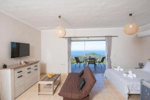 a living room with a bed and a couch and a tv at Agnantio in Agios Nikitas