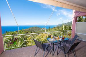 a table and chairs on a balcony with a view of the ocean at Agnantio in Agios Nikitas