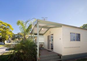 a small white house with a porch at Echo Holiday Parks - Normanville in Normanville