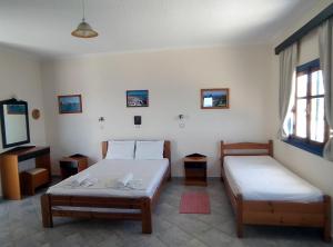 a room with two beds and a mirror at B & N Melas Studios in Amoopi