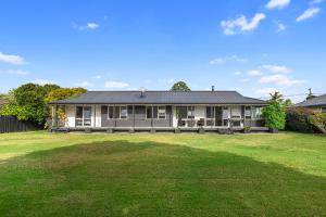 ワイプにあるFamily Haven - Waipu Holiday Homeの前に広い庭がある家