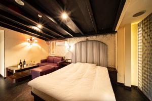 池田Hotel MINT Osaka Airport的配有床和沙发的酒店房间