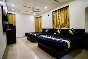 a living room with two beds and a ceiling at Hotel Shri Govind in Shirdi +20 photos