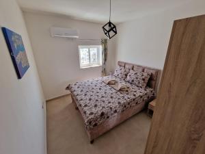 a small bedroom with a bed and a window at Sky Apartment 3 in St Paul's Bay
