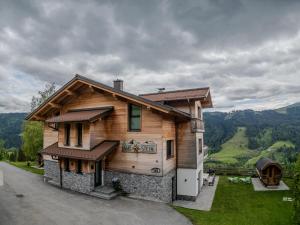 a wooden house with a view of the mountains at Gut Stein Panoramalodge in Mühlbach am Hochkönig