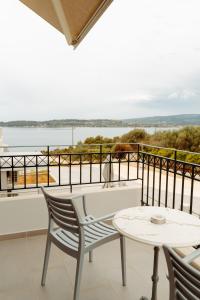 a balcony with a table and chairs and a view of the water at Limanaki Hotel in Lassi