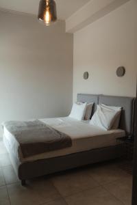 a bedroom with a bed with white sheets and pillows at Limanaki Hotel in Lassi