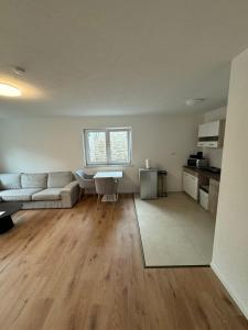 an empty living room with a couch and a table at Neues Apartment Ehingen 2.0 in Ehingen +7 photos
