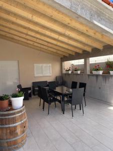 a patio with a table and chairs and a wooden ceiling at Apartments M&K in Vinišće