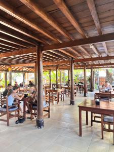 a group of people sitting at tables in a restaurant at Puri Bali Hotel in Lovina