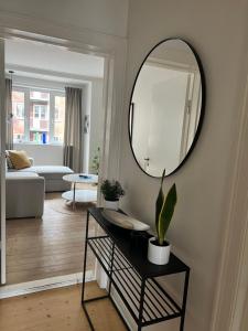 a living room with a mirror and a table with plants at Martha in Aalborg
