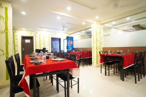 a dining room with red tables and chairs at Hotel Shri Govind in Shirdi