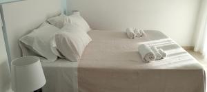 a white bed with white pillows and towels on it at Hotel Riviera in Silvi Marina