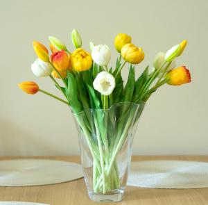 a glass vase filled with yellow and white flowers at Apartma Alina in Lucija