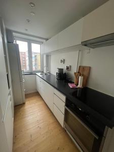 a kitchen with white cabinets and a black counter top at Martha in Aalborg