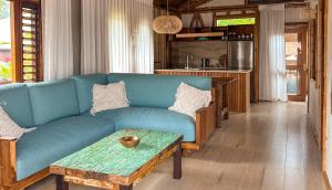 een woonkamer met een blauwe bank en een tafel bij Magic Reef Bungalows in Rarotonga