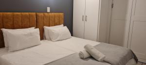 a bed with white pillows and a wooden headboard at Tenbury by the beachfront 806 in Durban